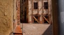 L’immagine mostra alcuni edifici del centro storico di Camerino che presentano opere provvisionali di messa in sicurezza temporanea, costituiti da  puntelli di ritegno e di sostegno in legno e tirantature metalliche
