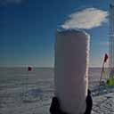 One of the first pieces of shallow ice-core drilled by the new system in the backround. Field tests close to Neumayer 3