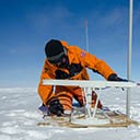 setting up one of the radar systems to measure the vertical deformation of the ice sheet at one of the candidate drilling sites at Little Dome C